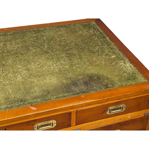 1012 - A Campaign style yew wood pedestal desk with leather top. 135x74x78cm