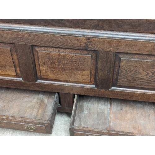 959 - An early George II oak press/house keepers cupboard with raised and fielded panels. With original wo... 