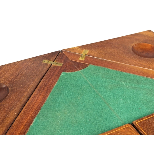 1030 - An Edwardian inlaid mahogany envelope turnover games table. 53.5x77.5cm