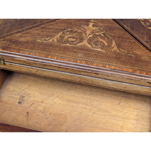 1030 - An Edwardian inlaid mahogany envelope turnover games table. 53.5x77.5cm