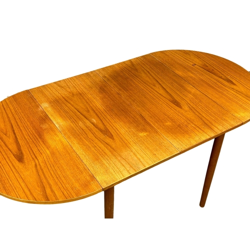 1052 - A Danish Mid Century teak drop leaf dining table in the manner of Arne Vidder. Open 168x84x73cm. Clo... 