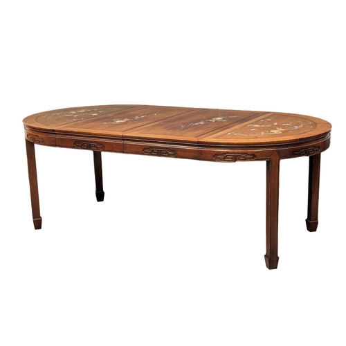 1057 - A Chinese rosewood 2 leaf extending dining table and 6 chairs with Mother of Pearl inlay.