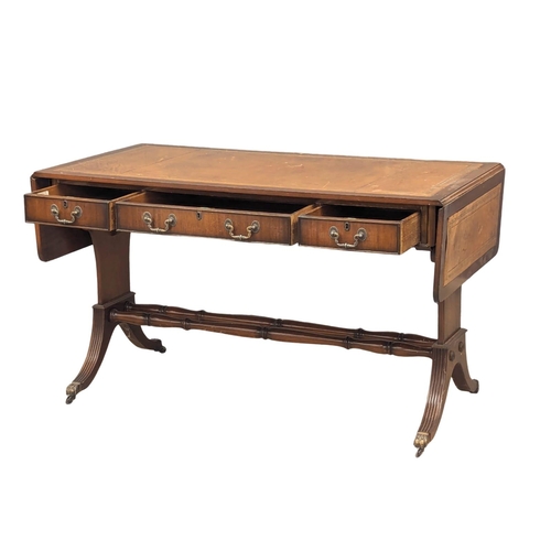 1087 - A mahogany writing desk/sofa table with leather top, 3 drawers, 3 dummy drawers and lion paw feet ca... 