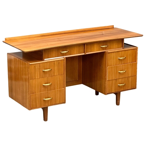 1097 - A Mid Century walnut desk/dressing table, 131cm x 49cm x 74.5cm