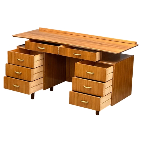 1097 - A Mid Century walnut desk/dressing table, 131cm x 49cm x 74.5cm