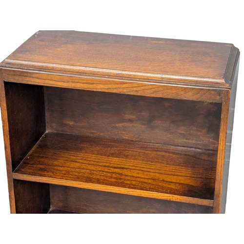 1106 - A vintage oak open bookcase with drop down paper rack. 48.5x22.5x105cm