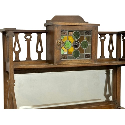 1153 - An Early 20th Century Arts & Crafts oak mirror back sideboard with stained glass panel door. Circa 1... 