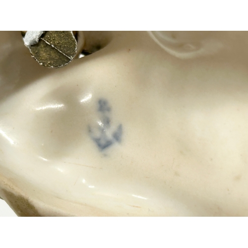 10 - A 19th Century porcelain nodding figurine. Blue anchor mark. Possibly Chelsea Porcelain. 12x10x12cm.