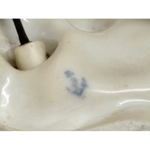 10 - A 19th Century porcelain nodding figurine. Blue anchor mark. Possibly Chelsea Porcelain. 12x10x12cm.