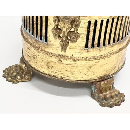 75 - A vintage Georgian style pierced brass jardiniere/planter with lion paw feet and rams head masks. 23... 