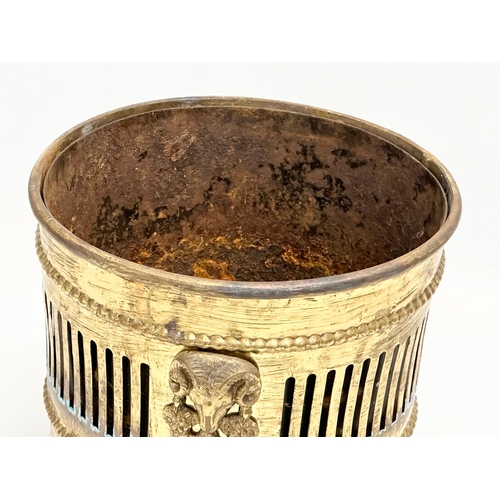 75 - A vintage Georgian style pierced brass jardiniere/planter with lion paw feet and rams head masks. 23... 