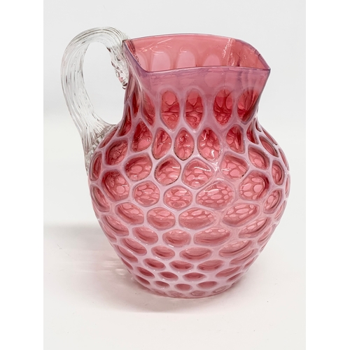 101 - A large 19th Century Victorian opalescent cranberry glass pitcher. 17x21x20cm