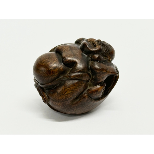 34 - A signed Late 19th/Early 20th Century Netsuke carved wooden Buddha.