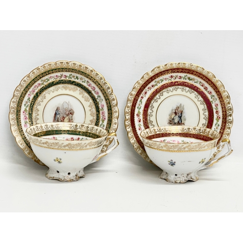 253 - A pair of Early 20th Century Rococo hand painted cups and saucers.