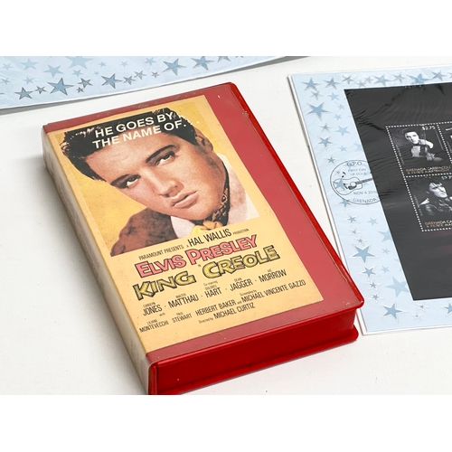 584 - A collection of Elvis Presley memorabilia. Including VHS tapes and stamps etc.