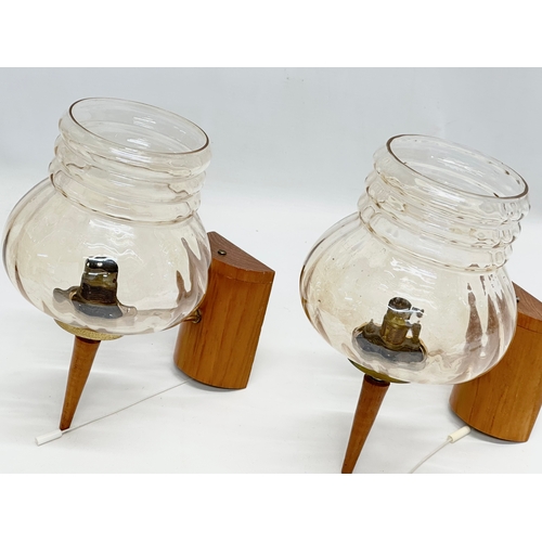 117I - A pair of Mid Century teak and brass wall lights with glass shades.