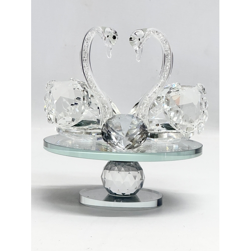 557 - A pair of crystal swans on rotating base. With box. 15x15x17cm