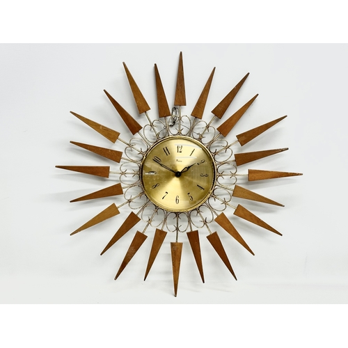 137 - A 1960’s Mid Century teak sunburst clock by Paico. 52cm