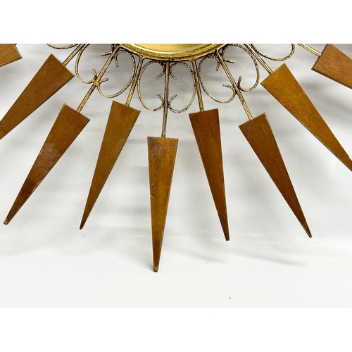 137 - A 1960’s Mid Century teak sunburst clock by Paico. 52cm