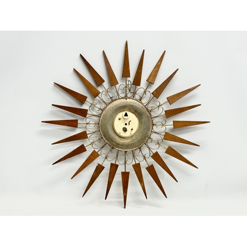 137 - A 1960’s Mid Century teak sunburst clock by Paico. 52cm