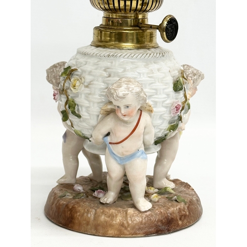 149 - A near pair of Late 19th/Early 20th Century German porcelain oil lamps. With Cupid and crusted flowe... 