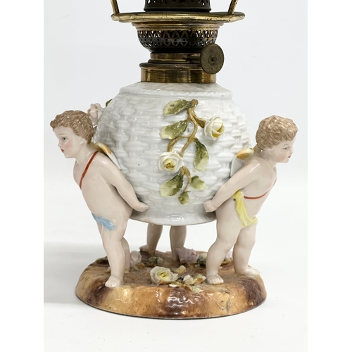 149 - A near pair of Late 19th/Early 20th Century German porcelain oil lamps. With Cupid and crusted flowe... 