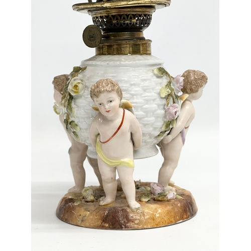 149 - A near pair of Late 19th/Early 20th Century German porcelain oil lamps. With Cupid and crusted flowe... 