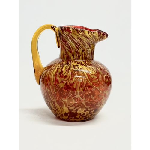 81 - An Early 20th Century art glass jug with gold mica flakes on a ruby ground, and amber glass handle. ... 