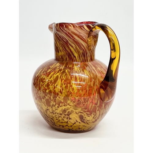 81 - An Early 20th Century art glass jug with gold mica flakes on a ruby ground, and amber glass handle. ... 