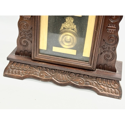 435 - A Late 19th Century American Gingerbread clock. With pendulum. 36x12x57cm.