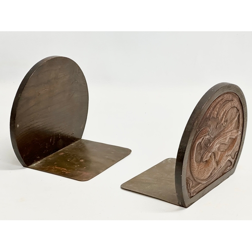 32 - A pair of Late 19th/ Early 20th Century bookends with embossed dragon leather panels in oak frames a... 