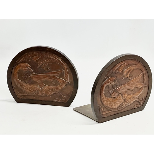 32 - A pair of Late 19th/ Early 20th Century bookends with embossed dragon leather panels in oak frames a... 