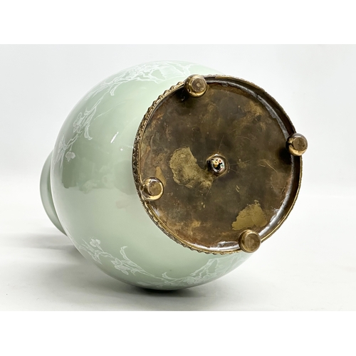 102 - A Chinese Celadon glazed table lamp with brass base. Decorated with white prunus leaves and birds in... 