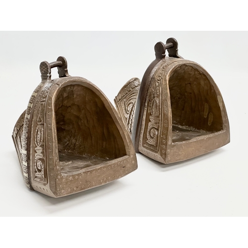 117 - A pair of 19th Century South American carved wooden stirrups with iron and silver metal mounts.