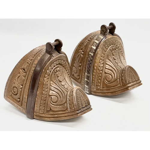 117 - A pair of 19th Century South American carved wooden stirrups with iron and silver metal mounts.