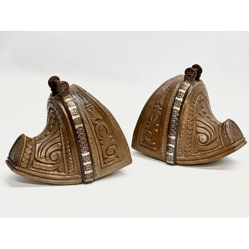 117 - A pair of 19th Century South American carved wooden stirrups with iron and silver metal mounts.