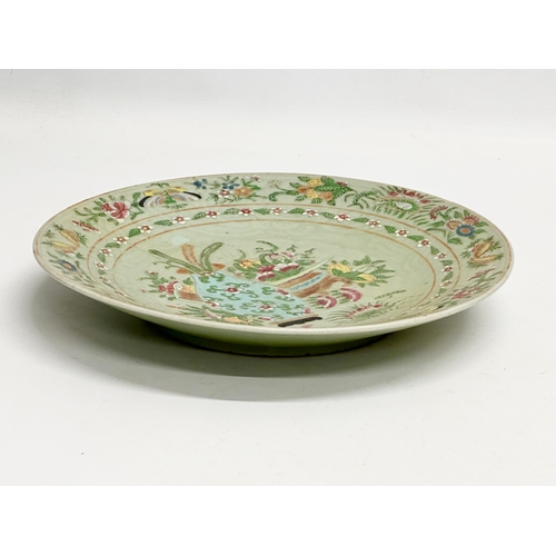 74 - A large 19th Century Chinese Famille Rose footed plate with a celadon glazed ground. Decorated with ... 