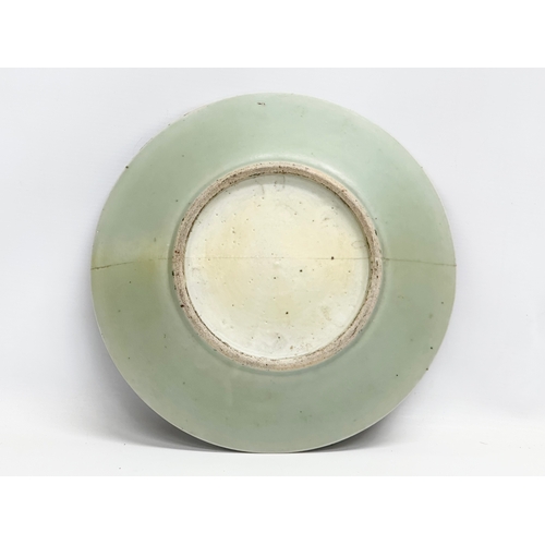 74 - A large 19th Century Chinese Famille Rose footed plate with a celadon glazed ground. Decorated with ... 