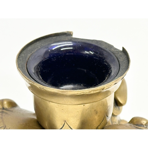 234 - A Late 19th Century brass foo dog ink well with Bristol Blue liner. 11.5x8.5cm.