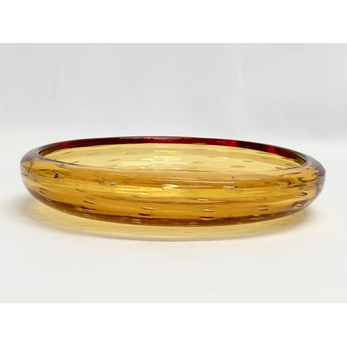 303 - A large controlled bubbles amber ass bowl designed by William Wilson for Whitefriars. 25x5cm.