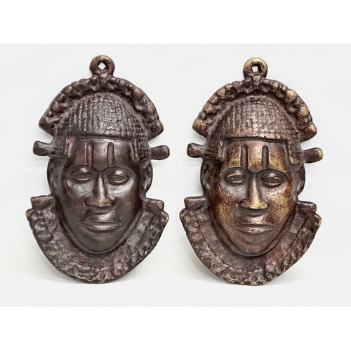 271 - A pair of vintage Bronze African masks. 18x29cm.