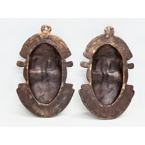 271 - A pair of vintage Bronze African masks. 18x29cm.