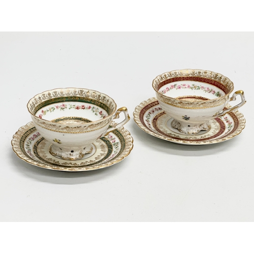 386 - A pair of Early 20th Century Rococo hand painted cups and saucers.