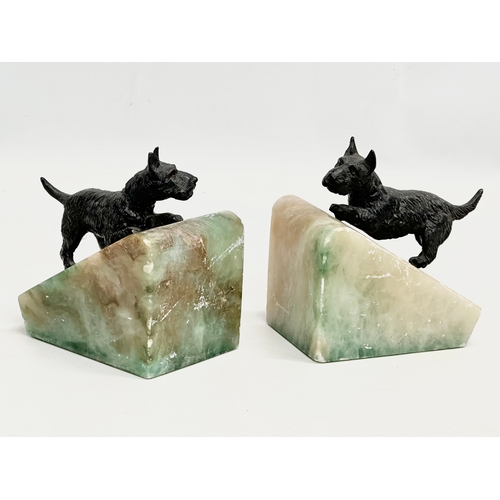 369 - A pair of Early 20th century onyx bookends with  speltre Scottie dogs. 11x8x12cm.