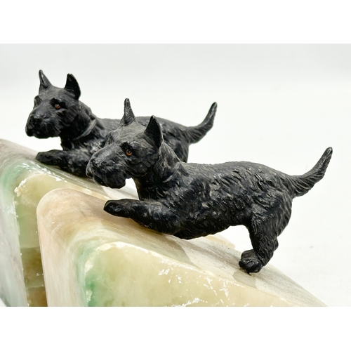 369 - A pair of Early 20th century onyx bookends with  speltre Scottie dogs. 11x8x12cm.