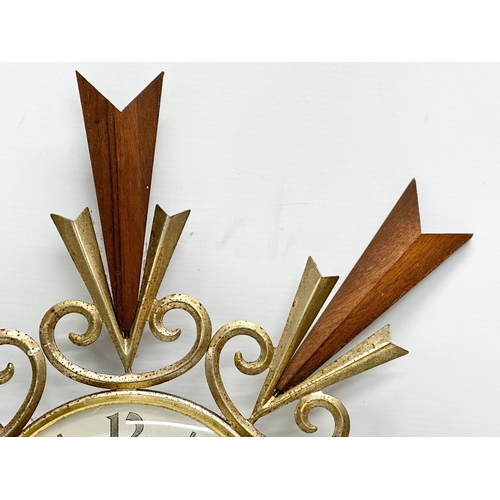 246N - A Mid Century teak sunburst clock. By Paico. 51cm