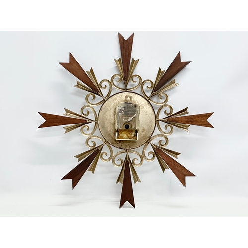 246N - A Mid Century teak sunburst clock. By Paico. 51cm