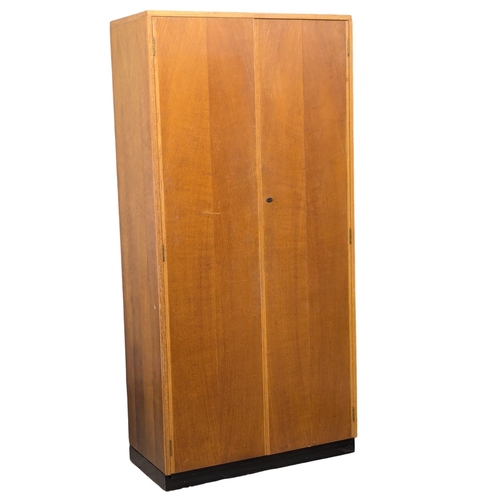 1165 - A tall Mid Century oak double door fitted side cabinet. 91.5x46x192cm