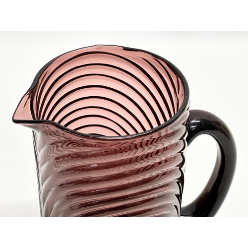 241 - A Mid/Late 20th Century amethyst swirl glass pitcher. 19x12x22cm.