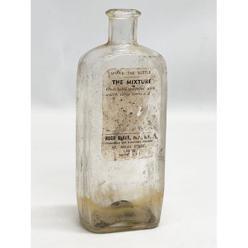 252 - A collection of Early 20th Century Northern Irish chemist bottles. 18cm, 19cm.